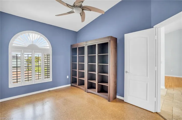 Unfurnished room featuring light tile patterned flooring, ceiling fan, and vaulted ceiling