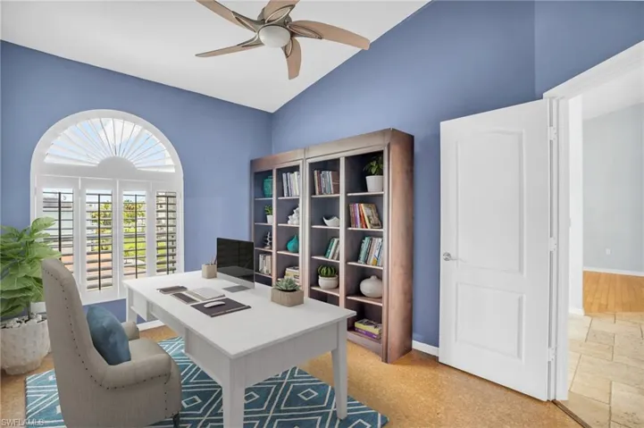 *Virtually Staged* Office space featuring high vaulted ceiling, light tile patterned floors, and ceiling fan
