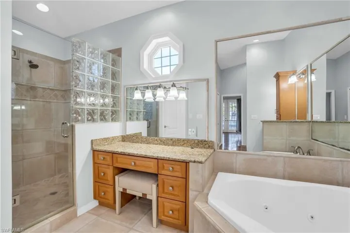 Bathroom featuring vanity, tile patterned floors, and separate shower and tub