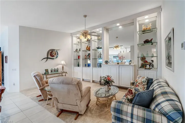 Living room with ceiling fan, light tile patterned flooring, recessed lighting, and baseboards