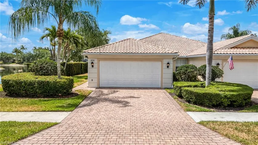 Single story home with stucco siding, driveway, an attached garage, and a tile roof
