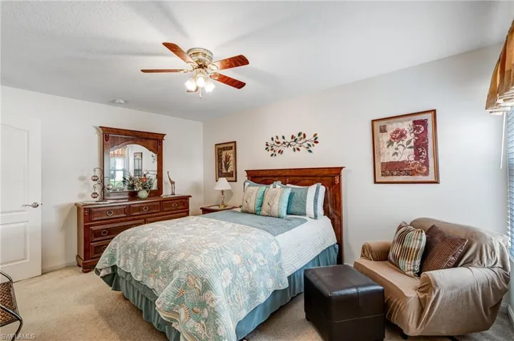 Bedroom featuring light colored carpet and a ceiling fan
