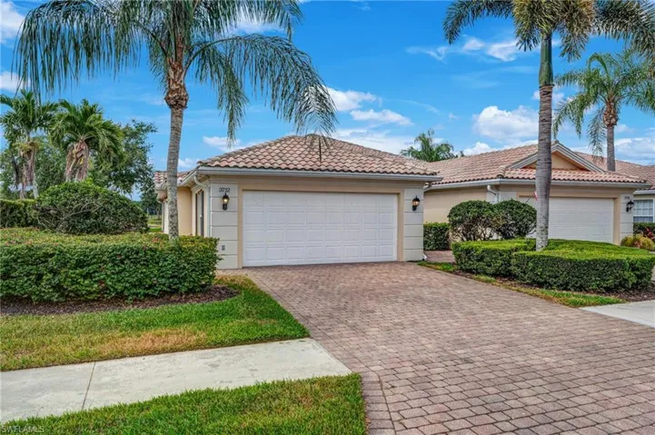 Mediterranean / spanish-style house with stucco siding, driveway, an attached garage, and a tiled roof