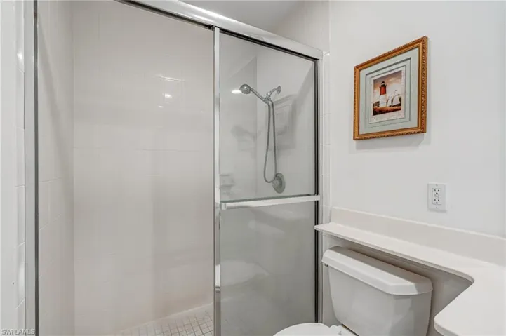 Bathroom featuring toilet and a stall shower