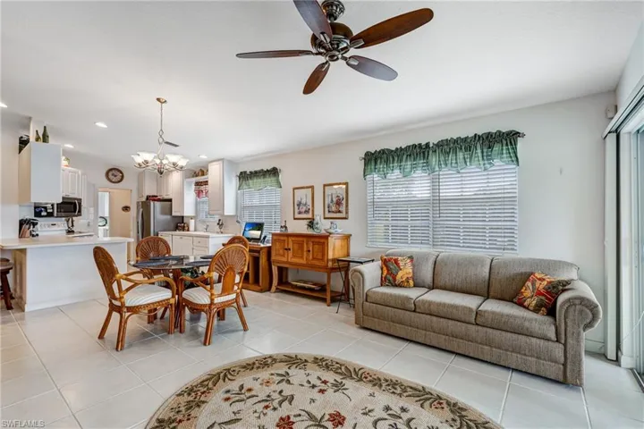 Living area featuring a chandelier, ceiling fan, light tile patterned floors, and recessed lighting