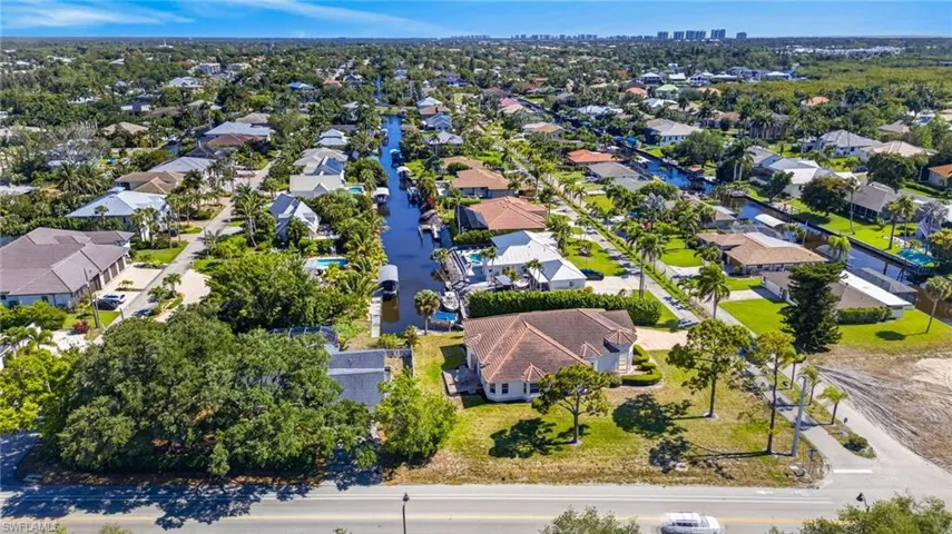 Aerial perspective of a waterfront residential community featuring a canal with boat docks