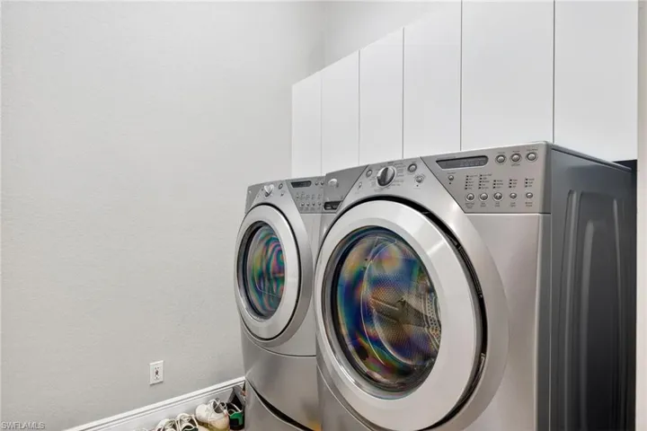 Laundry area featuring white cabinetry with ample storage