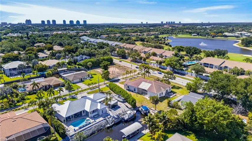 Waterfront property featuring a private boat dock, personal watercraft lifts, and a sparkling pool