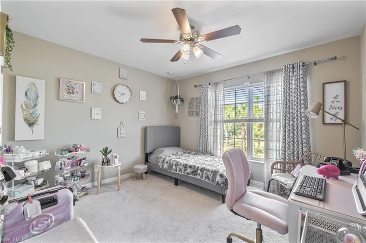 Bedroom featuring baseboards, a ceiling fan, and carpet