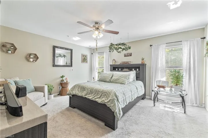 Carpeted bedroom featuring baseboards and a ceiling fan