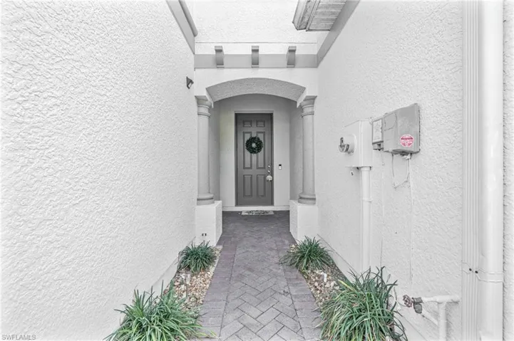 Doorway to property featuring stucco siding