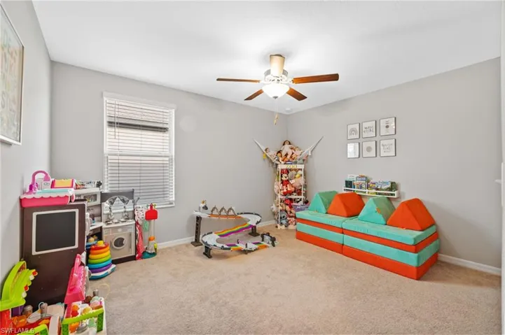 Rec room featuring ceiling fan and carpet
