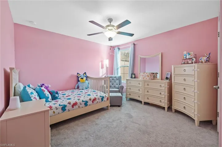 Carpeted bedroom featuring ceiling fan