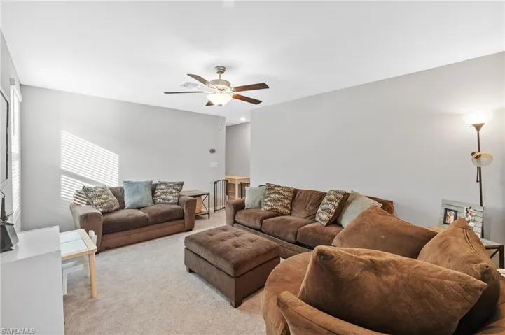 Living room featuring light carpet and ceiling fan