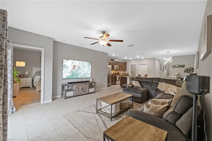 Living room with ceiling fan, light tile patterned floors, and sink
