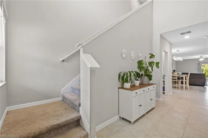 Stairs with tile patterned floors and ceiling fan