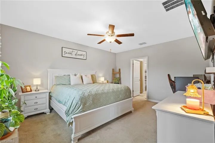 Bedroom with ceiling fan and light carpet