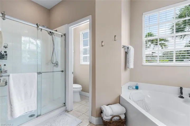 Bathroom with a bath, a stall shower, and tile patterned flooring