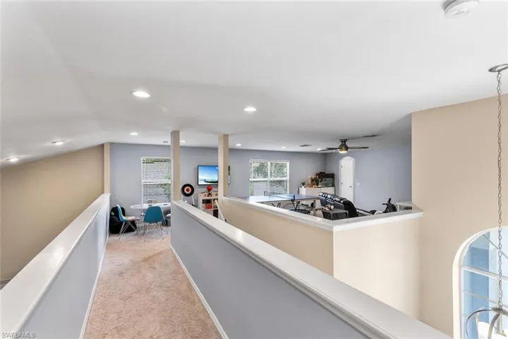 Corridor featuring light colored carpet and recessed lighting