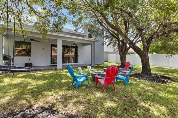 Fenced backyard with ceiling fan and an outdoor fire pit