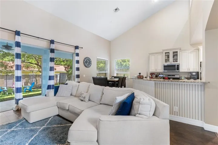 Living area featuring high vaulted ceiling and dark wood-type flooring