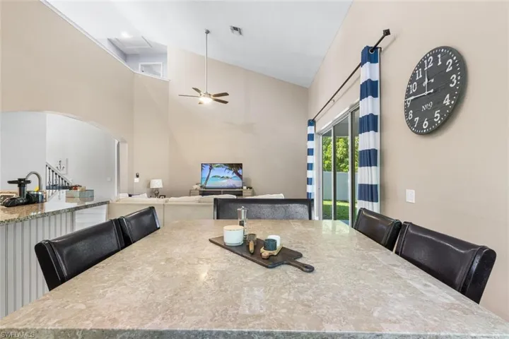 Dining area with vaulted ceiling, a ceiling fan, and arched walkways