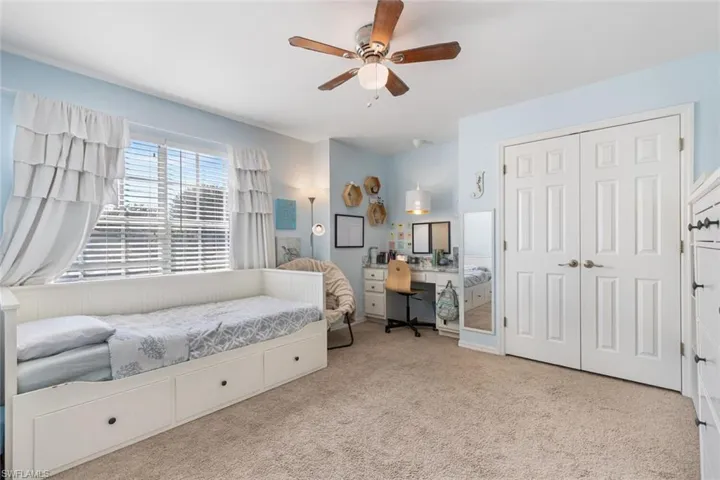 Bedroom featuring carpet flooring, a closet, ceiling fan, and an office area