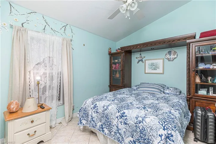 Tiled bedroom with vaulted ceiling and ceiling fan