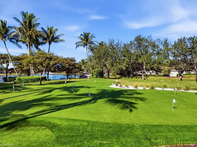 View of home's community with a putting area, a yard, and a water view
