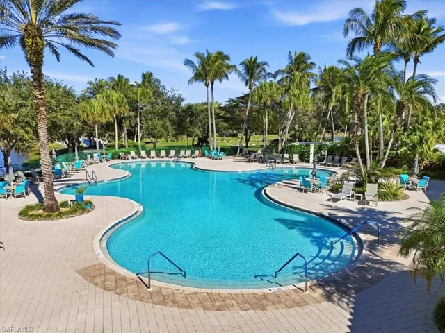 Community pool featuring a patio and view of scattered trees