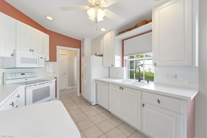 Kitchen with white cabinetry, white appliances, light countertops, recessed lighting, and decorative backsplash