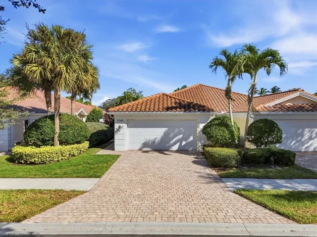 Mediterranean / spanish home with decorative driveway, an attached garage, a tiled roof, and stucco siding
