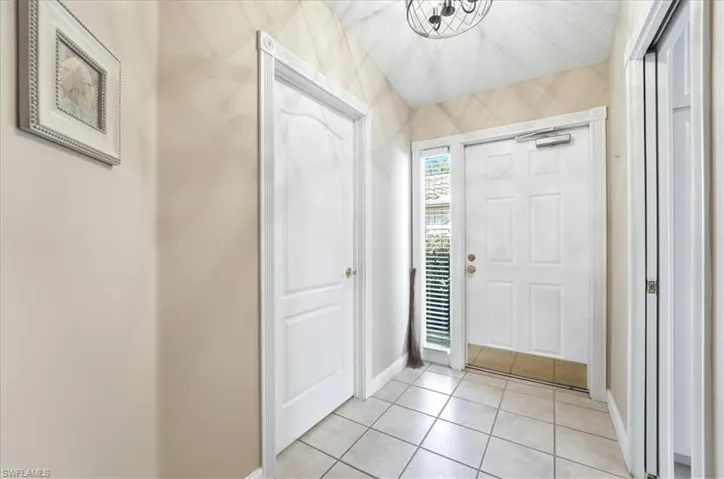 Foyer entrance featuring baseboards and light tile patterned floors