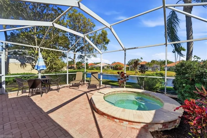 View of pool with a lanai, a water view, a residential view, a sunroom, and a patio area