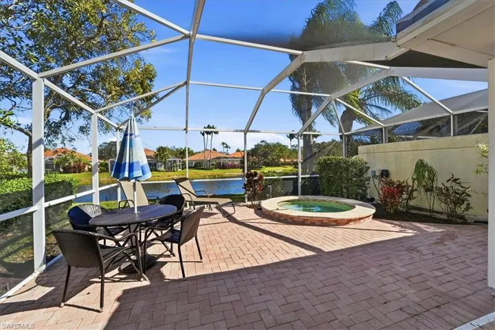 View of patio with a sunroom, glass enclosure, and an in-ground hot tub