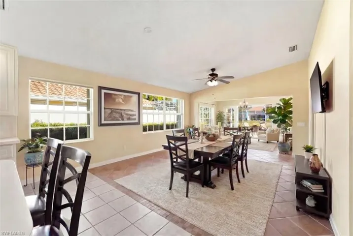 Virtually Staged Dining space featuring lofted ceiling, light tile patterned floors, and ceiling fan