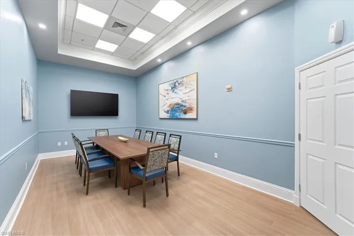 Dining area featuring light wood-style flooring, crown molding, a paneled ceiling, and a tray ceiling