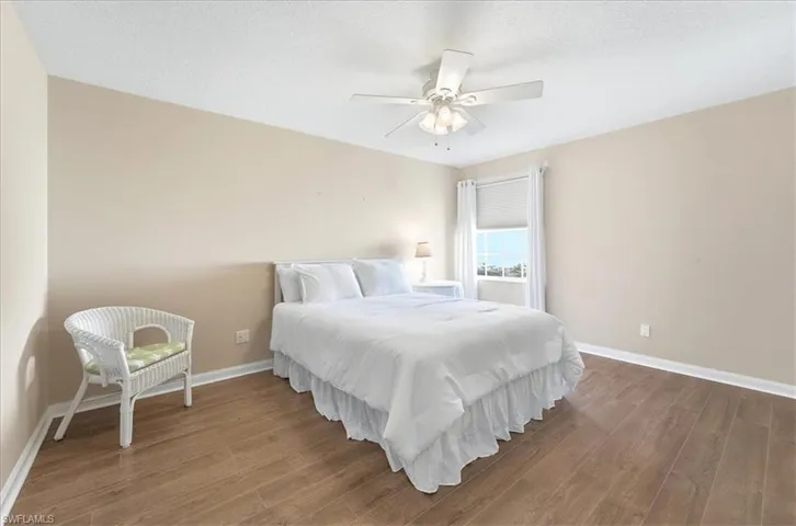 Bedroom with wood finished floors, a ceiling fan, and a textured ceiling