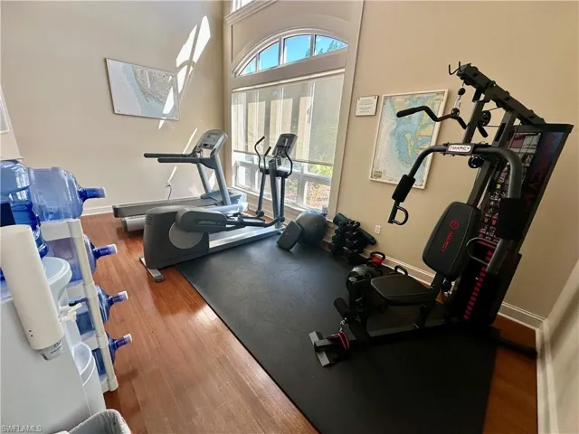 Workout room with a high ceiling and dark wood finished floors