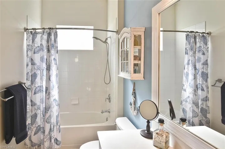 Full bath with vanity and shower / bath combination with curtain