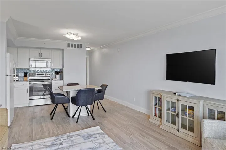 Dining space featuring ornamental molding and light hardwood / wood-style flooring