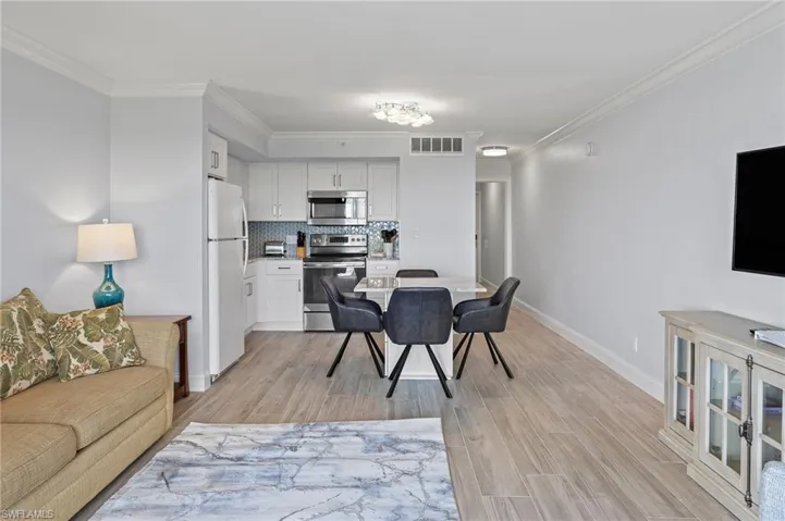 Dining space with crown molding and light wood-type flooring
