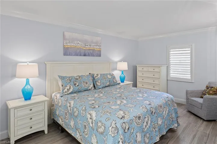 Bedroom with crown molding and hardwood / wood-style flooring