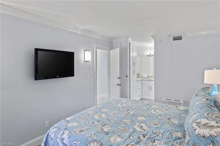 Bedroom with ornamental molding and ensuite bathroom