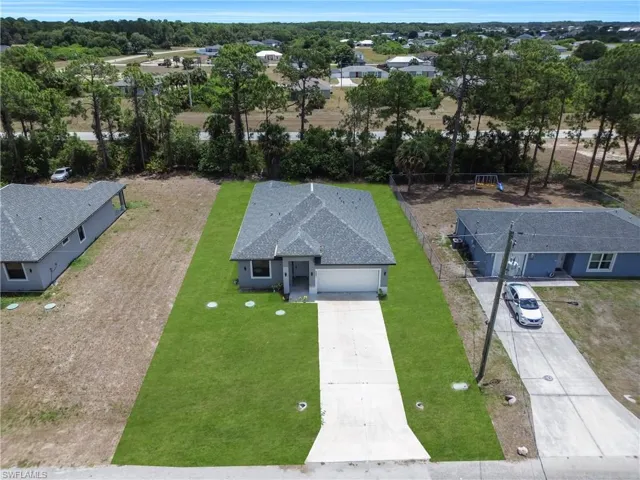 Contemporary single-story residence featuring a gray exterior and dark shingle roof