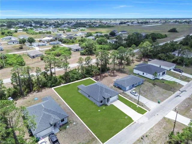 Contemporary-style residence featuring a dark shingle roof and a concrete driveway