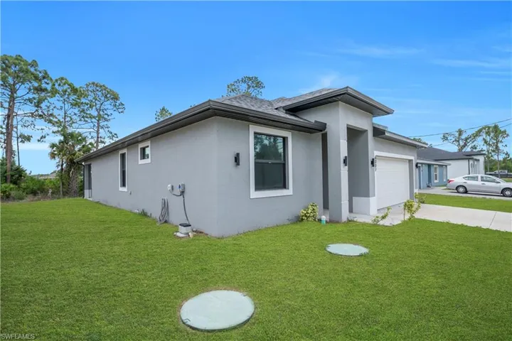 Contemporary-style home featuring a gray stucco exterior and dark-framed windows