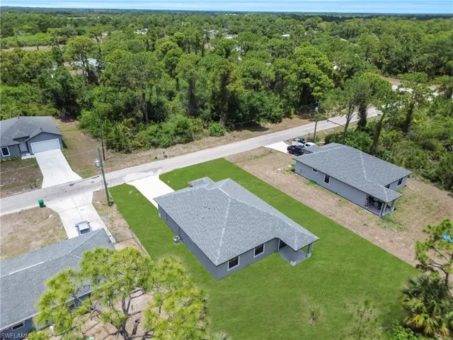 Newly constructed property featuring a gray exterior, a dark gray shingle roof, and a concrete driveway