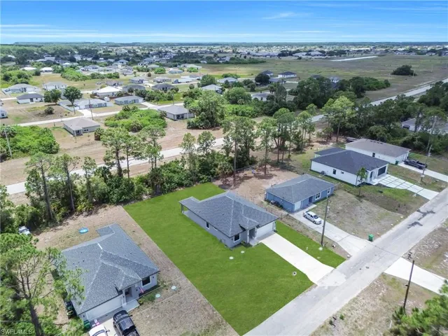 Aerial perspective showcasing residential properties with manicured lawns and concrete driveways