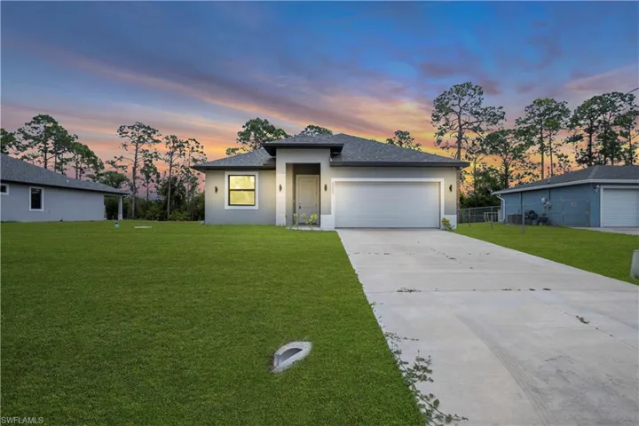 Contemporary single-story residence featuring a gray exterior finish, a dark shingle roof, and a two-car garage with a white door